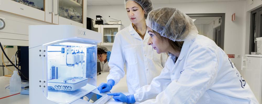 Three women working with a bioprinting machine 