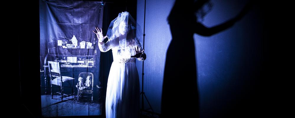 En person i vita kläder i ett mörkt rum