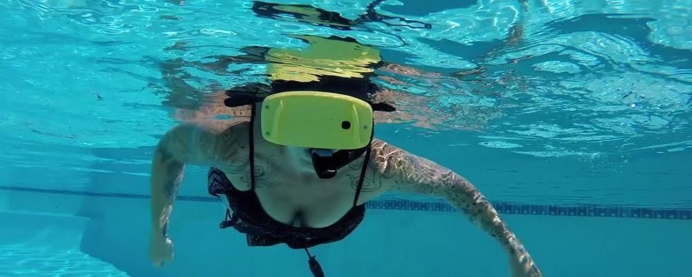 Person som simmar med VR-visir i bassäng
