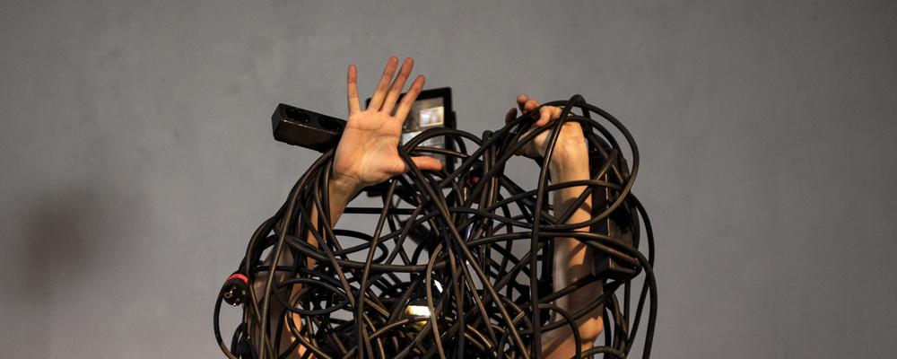A person's hands tangled up in cables