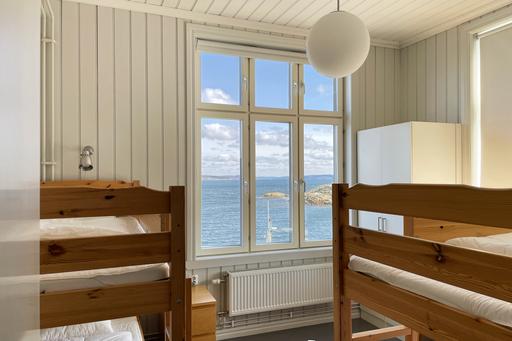Bild ifrån rum i sommarlabb, två dubbelsängar och utsikt mot havet.