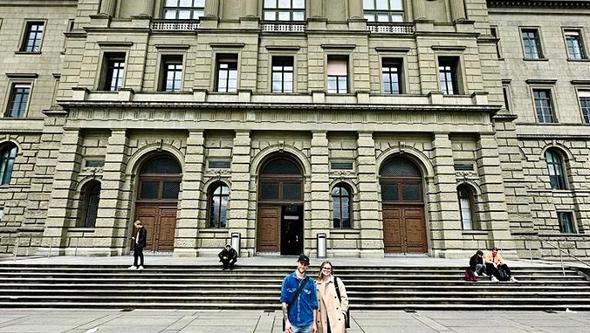 Två studenter står framför en universitetsbyggnad i Schweiz. 