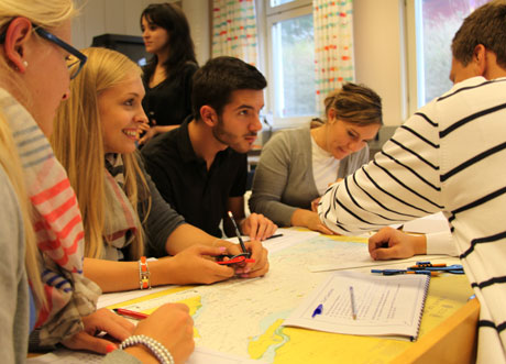 Studerande vid bord med sjökort