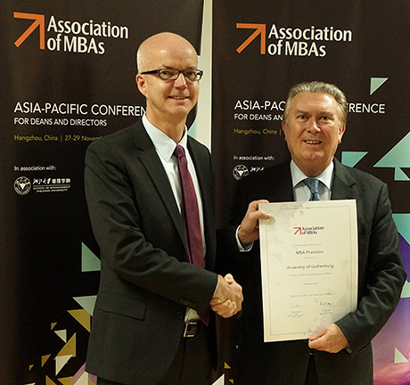 Per-Olof Larsson, VD, för GU School of Executive Education, tilldelas certifikatet for AMBA-ackrediteringen från Sir Paul Judge, ordförande för Association of MBAs 