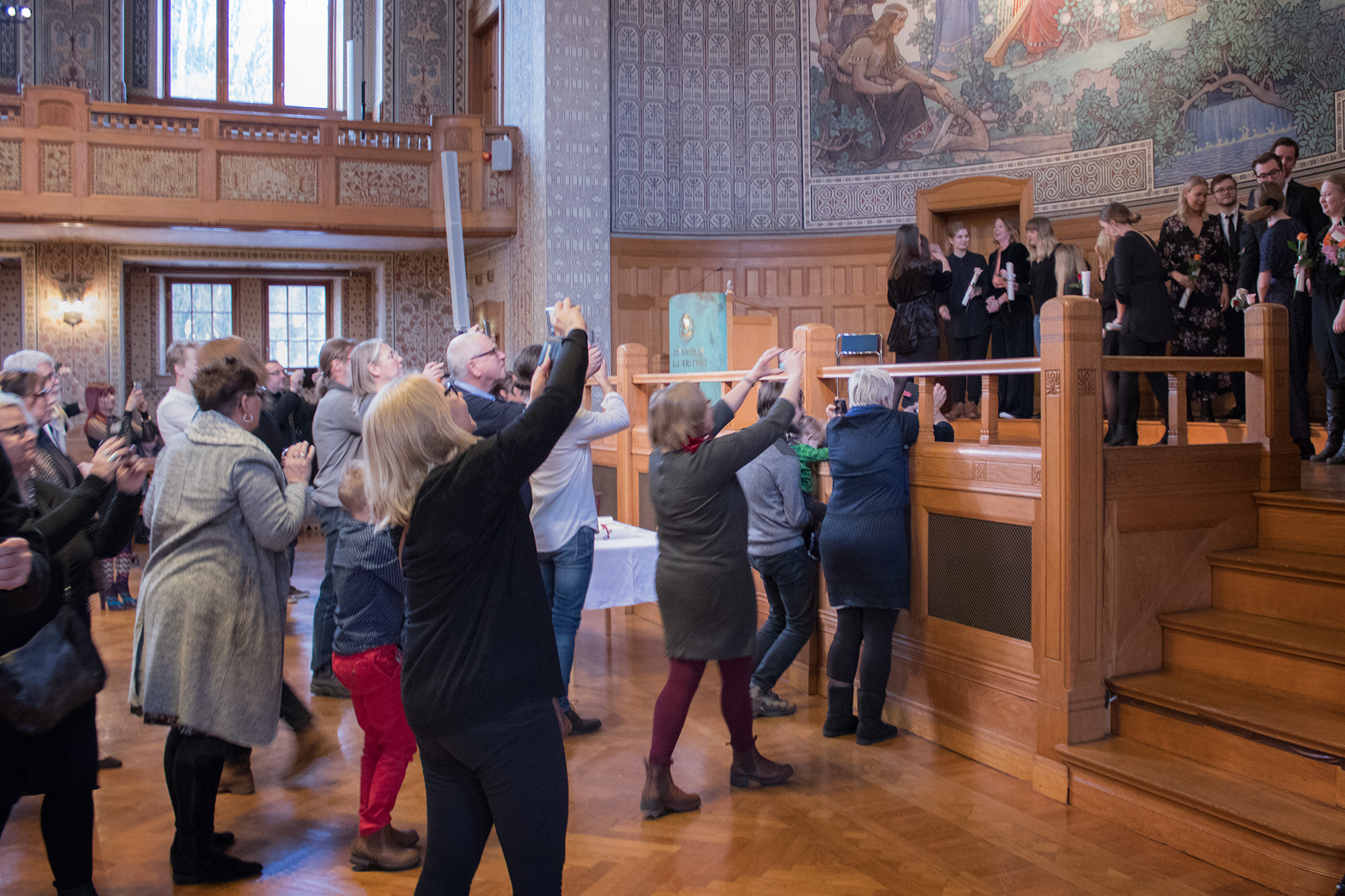 Anhöriga fotograferar de nyutexaminerade studenterna