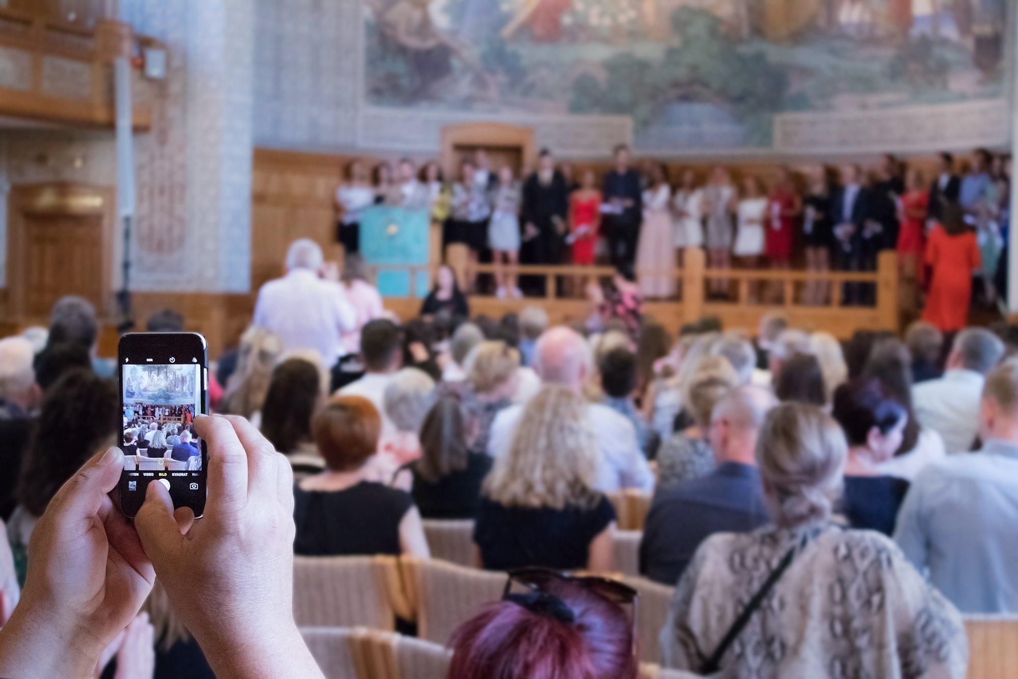 Anhöriga fotograferar studenterna som just avslutat sina program vid Förvaltningshögskolan
