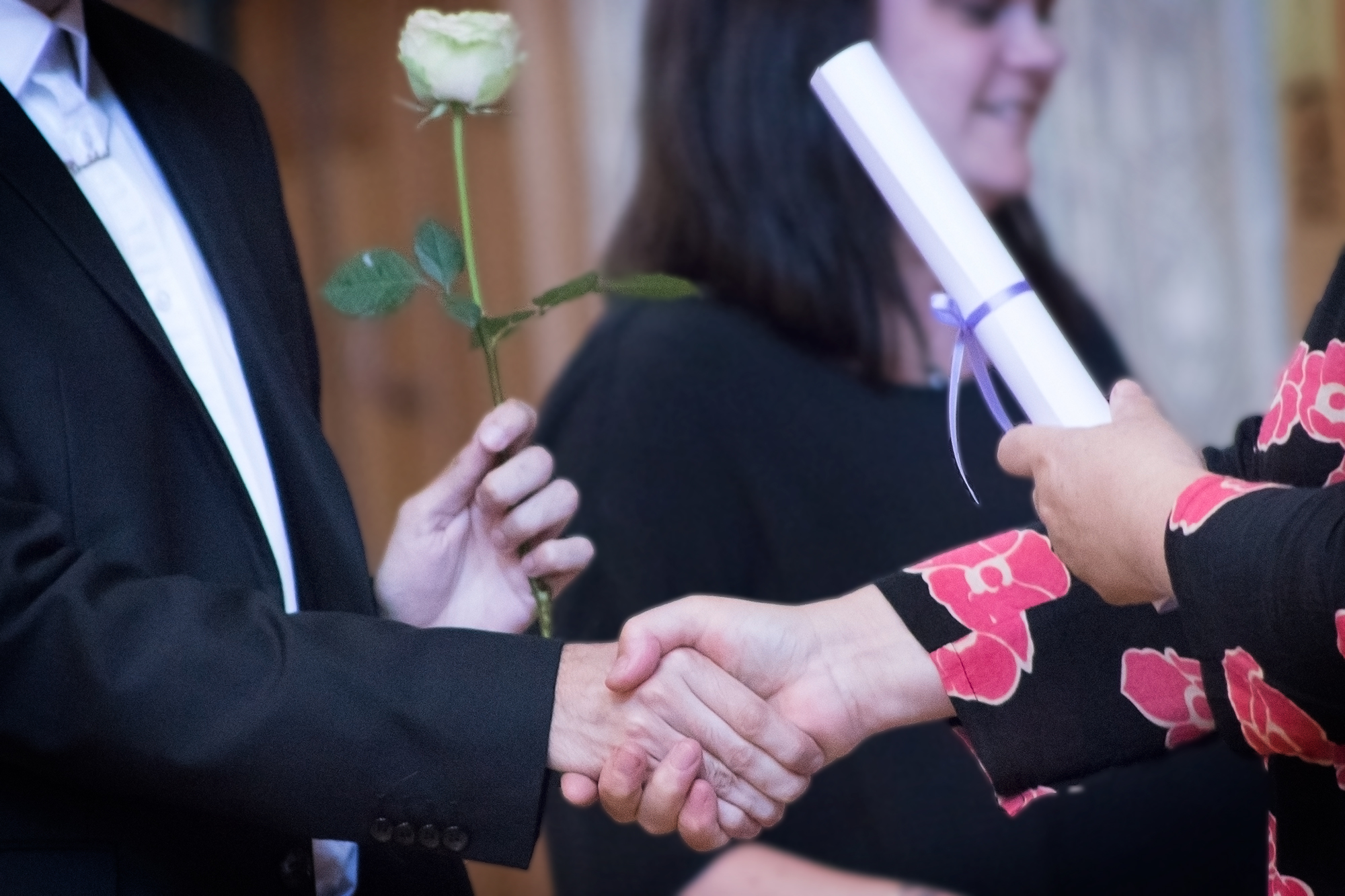 Förvaltningshögskolans studenter får blommor och diplom vid examensceremonin.