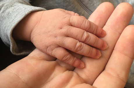 Foto av vuxenhand och barnhand