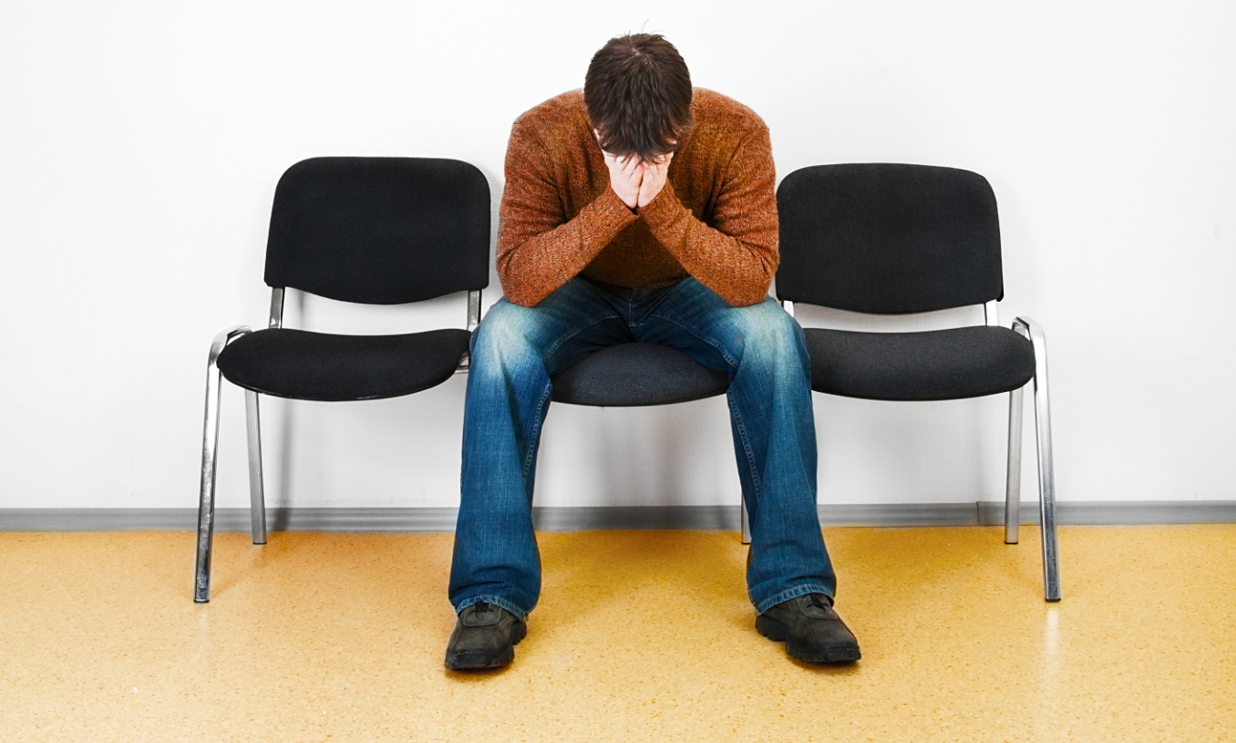 Foto på en man som har ansiktet i händerna