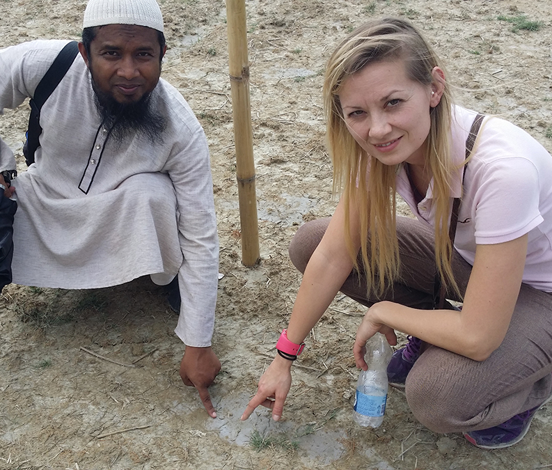 Johanna Lethin visiting Bangladesh, pointing at soil.