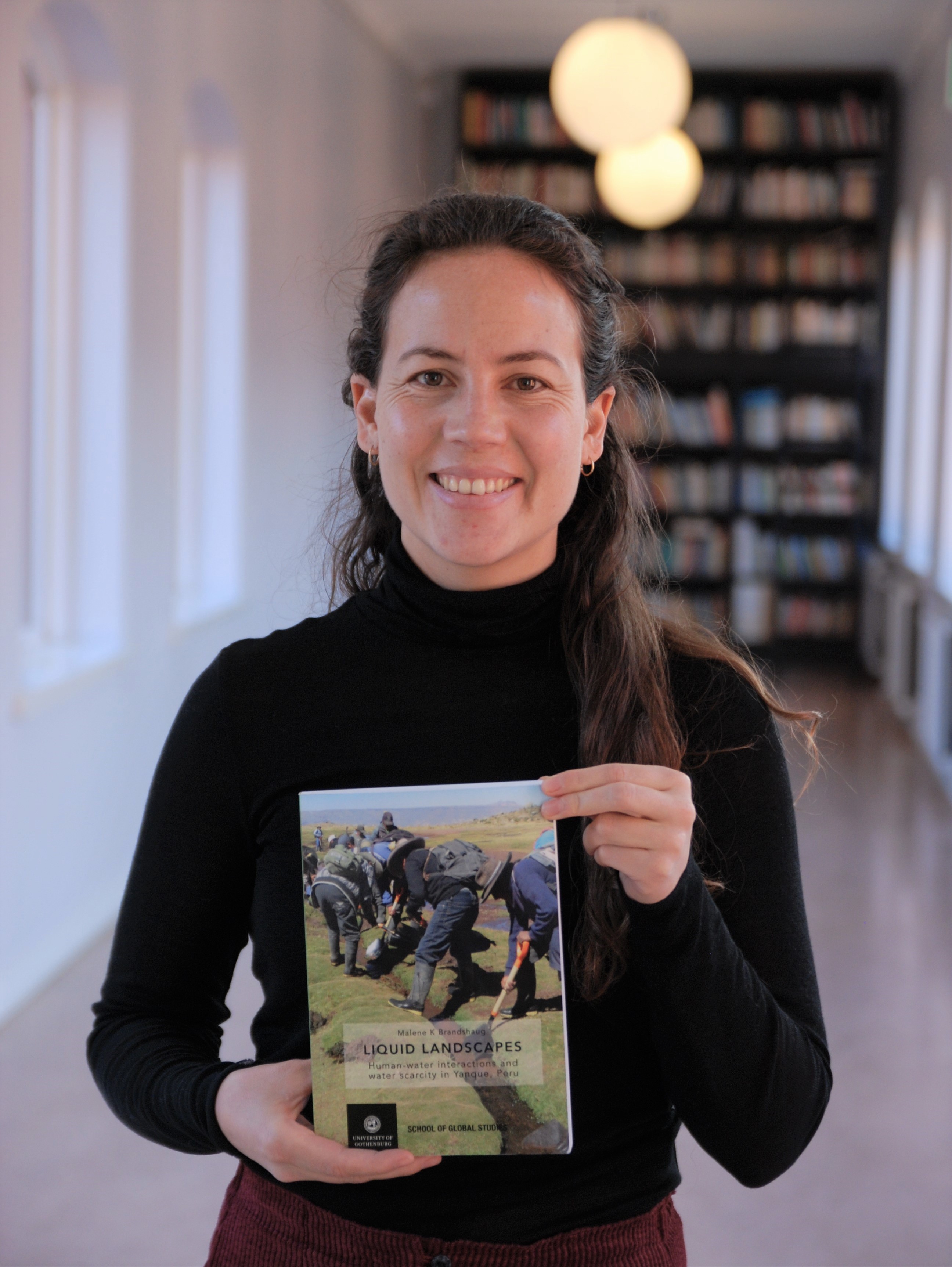 Malene K Brandshaug with her PhD thesis ‘Liquid landscapes: Human-water interactions and water scarcity in Yanque, Peru