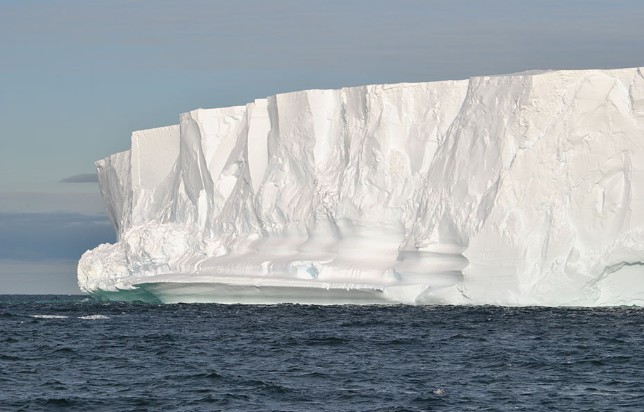 Antarktis mäktiga glaciärer står upp som vita kantiga bergsmassiv ur havet.