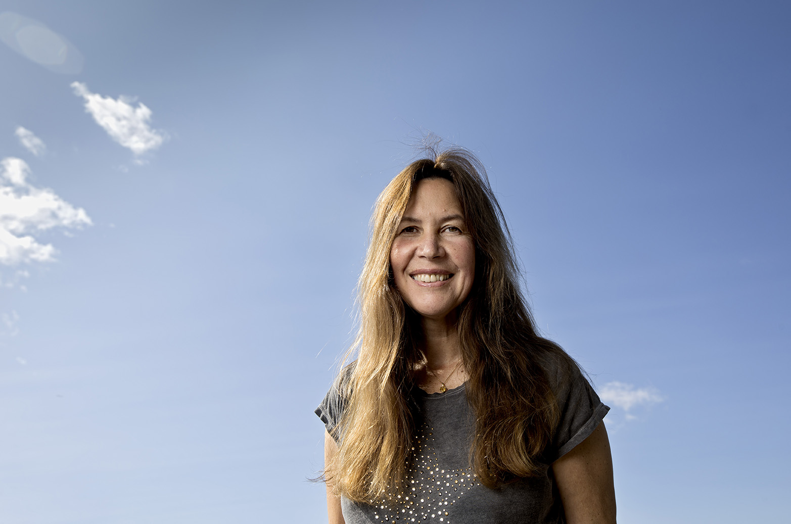 Maria Sundin ler med en blå himmel i bakgrunden.