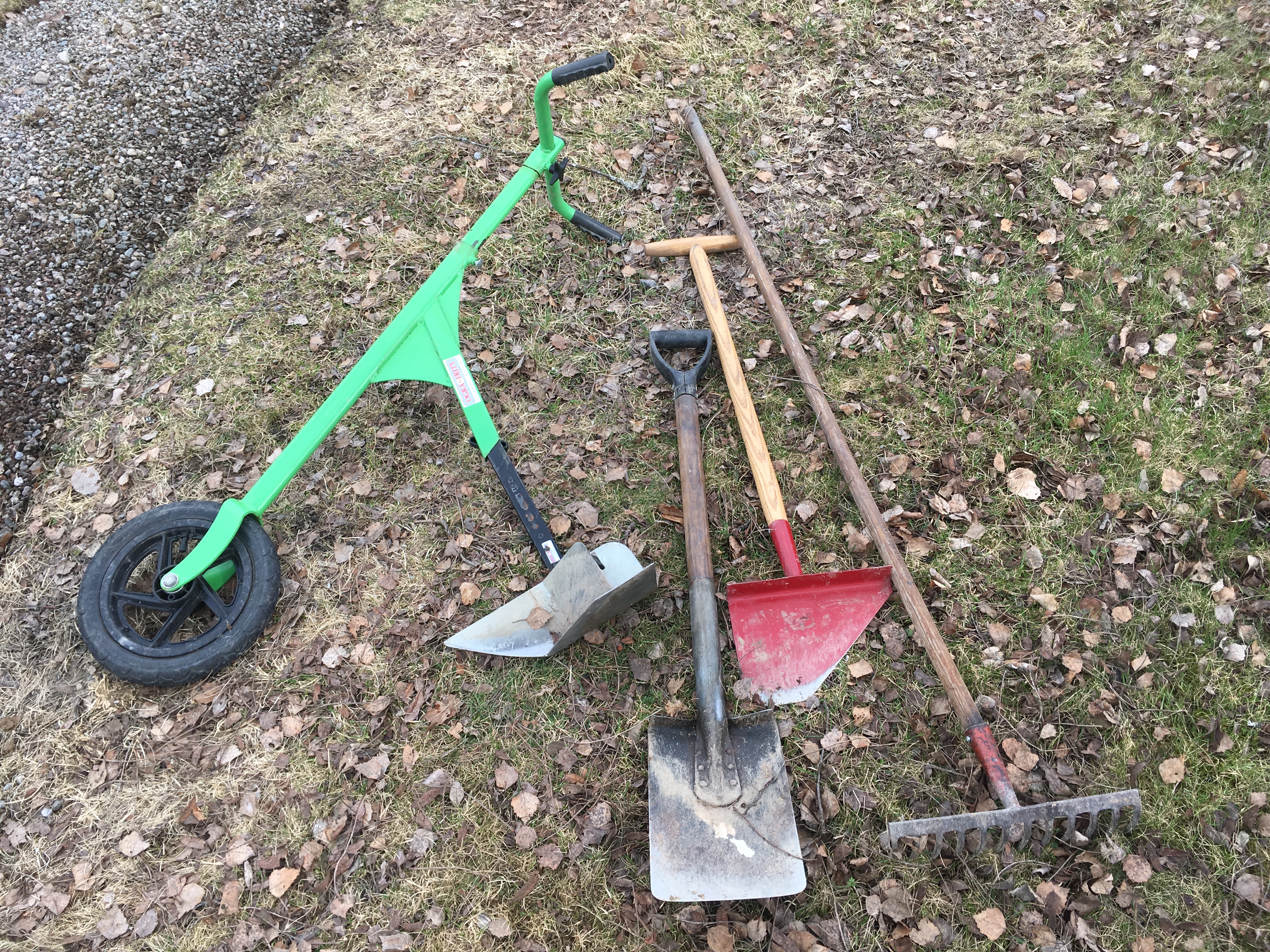 fyra trädgårdsredskap som ligger på marken. 