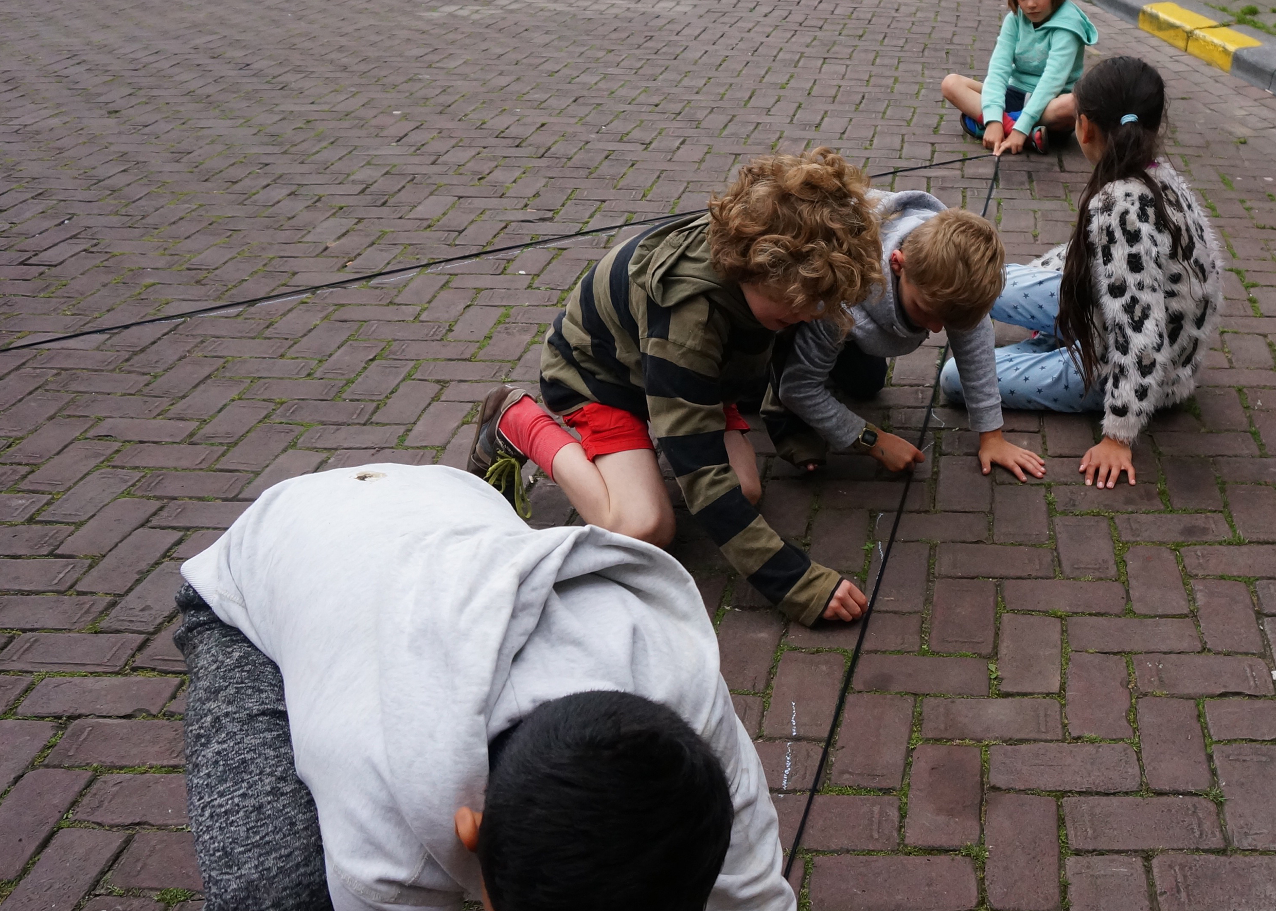 Barn ritar på marken under en workshop