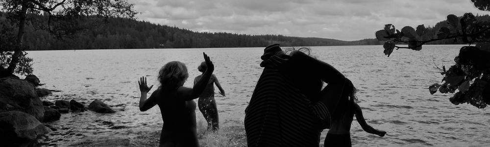 glada människor springer ut och badar i en sjö