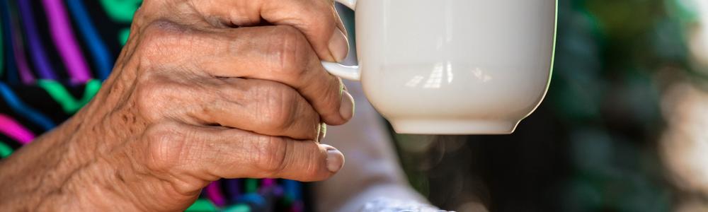 Old woman´s hand holding a teacup