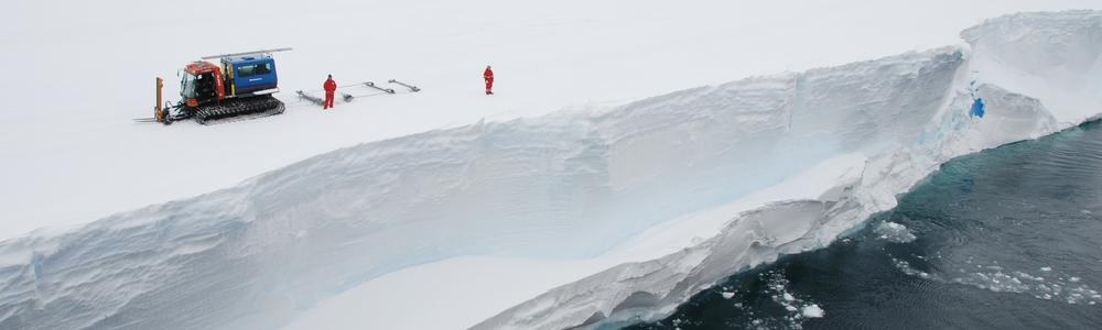 Två forskare syns på avstånd i polarmiljö. Står vid stup.