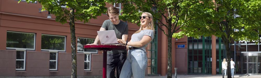 Happy students outdoors at table