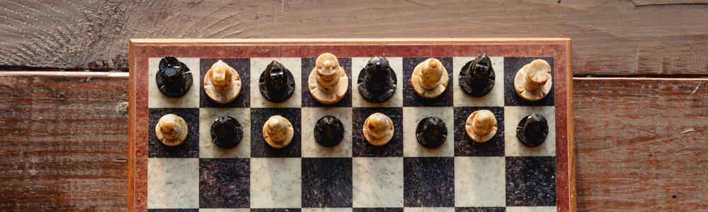 Ett bräde med schackpjäser på varsin sida.