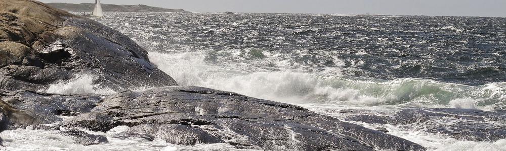 Waves hit the stony sea shore.