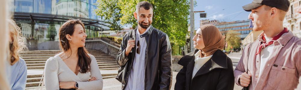 En grupp studenter nedanför trappan vid A-huset på Pedagogen