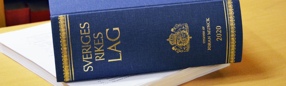 Foto på lagbok ovanpå en trave papper