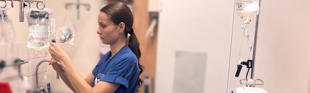 en sjuksköterska förbereder ett dropp i ett medicinförråd