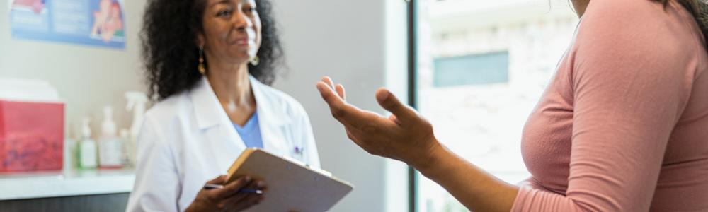 gravid kvinna som diskuterar med doktor 