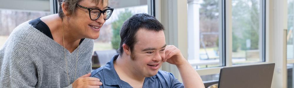 person med downs syndrom sitter vid dator 