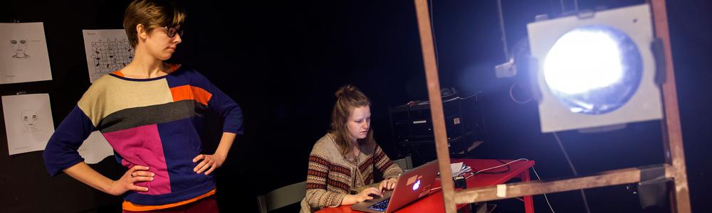 Två personer i en blackbox med scenbelysning.