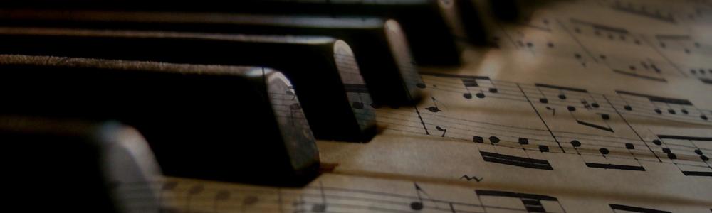 Svarta tangenter över notpapper.