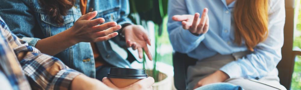 Inzoomad bild av tre personer som är involverade i ett samtal.