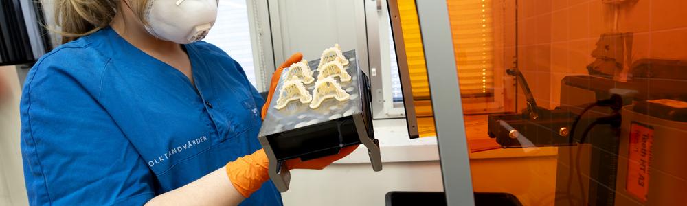 Bild på tandtekniker som arbetar vid 3D-printer