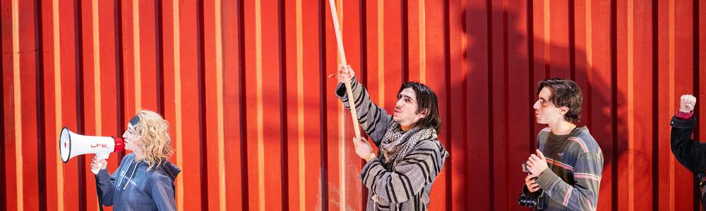 Tre personer framför en container