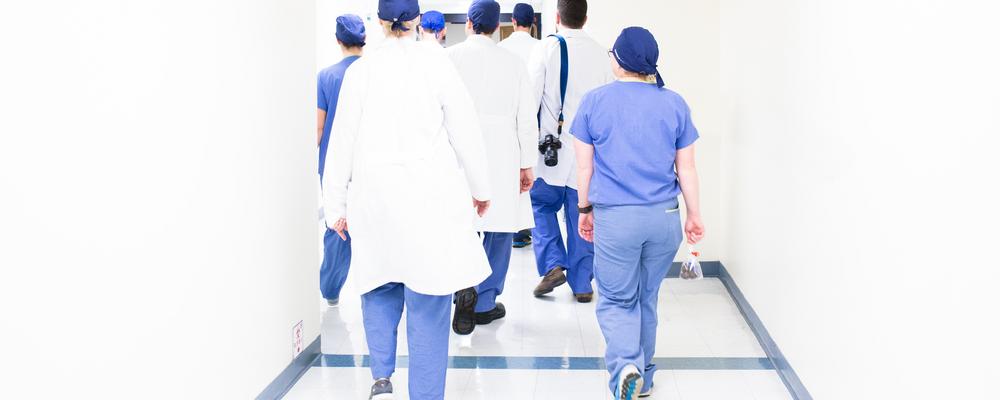 en grupp vårdpersonal går i en korridor