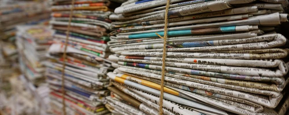 Large bundle of newspapers bound by string