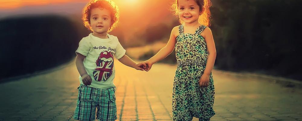 Boy and girl standing holding hands outside