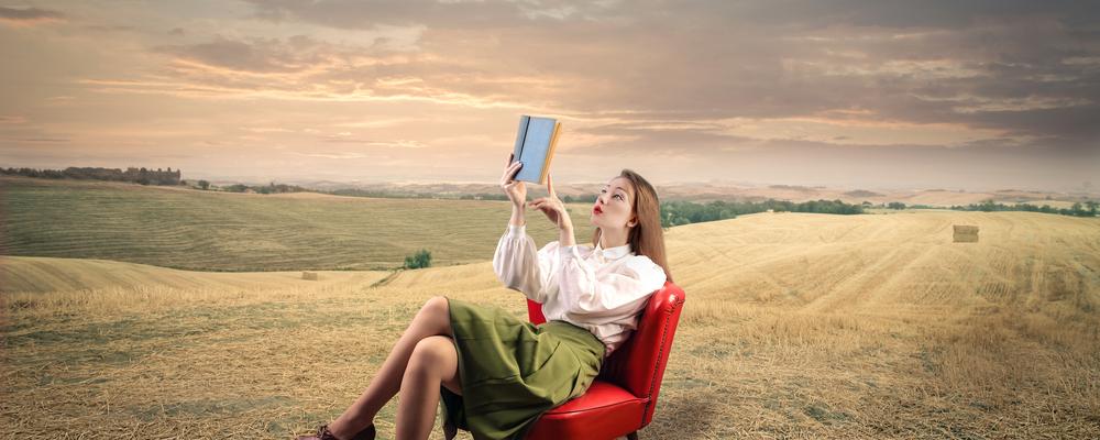 Kvinna läser bok på landsbygden