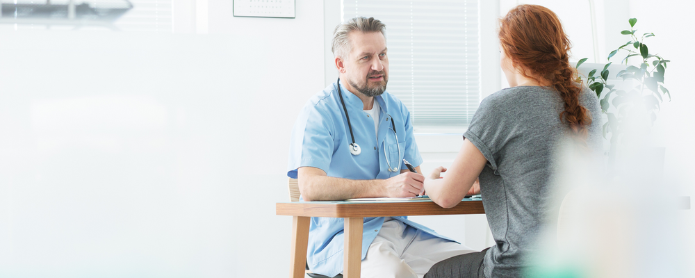 Foto på två personer som sitter och pratar med varandra