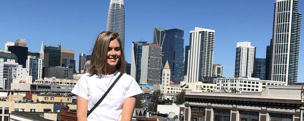 Kristina Johansson sitter med utsikt över San Franciscos skyskrapor bakom sig.