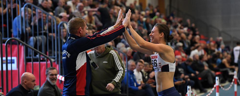 En tränare och idrottare gör high-five.