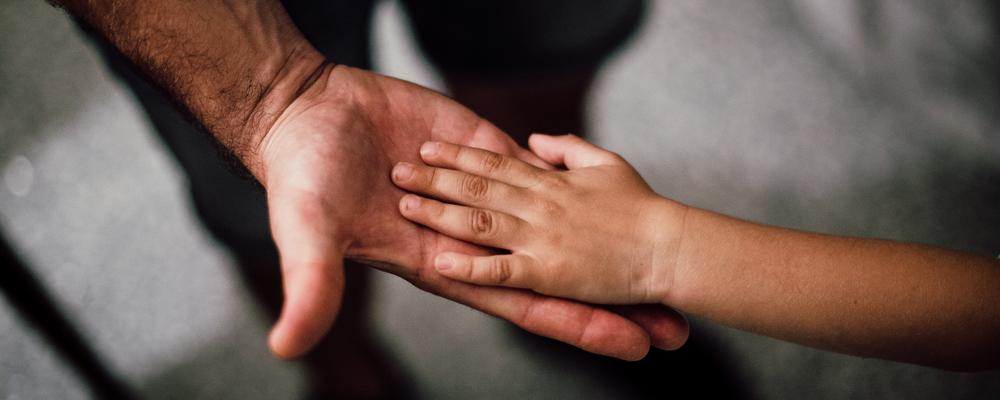Photo of child's hand in a grown up's hand