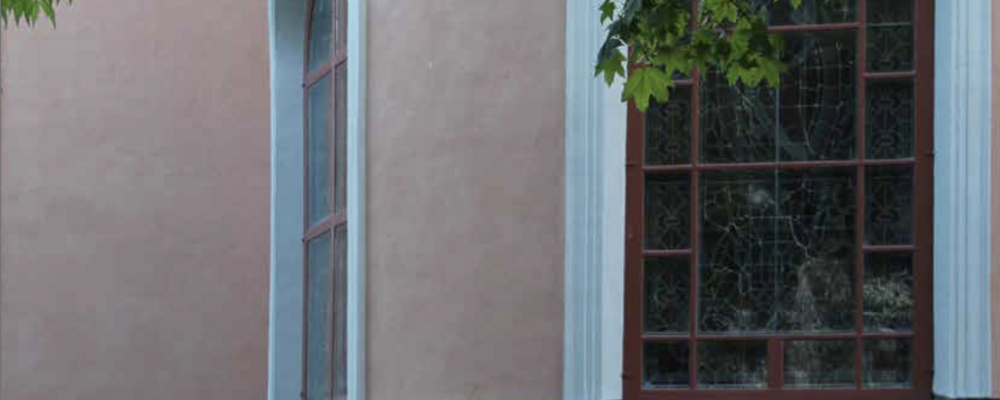 Bilden visar del av den rosa fasaden på Barkeryds kyrka