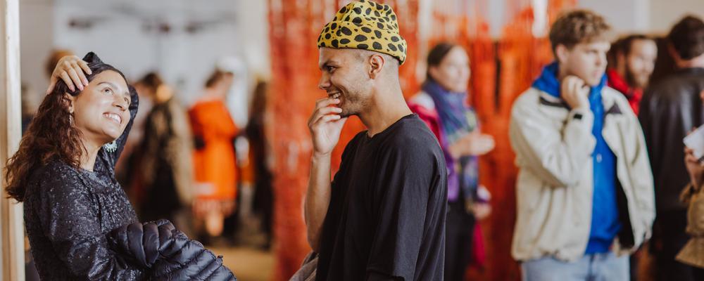 Personer skrattar i en utställningsmiljö