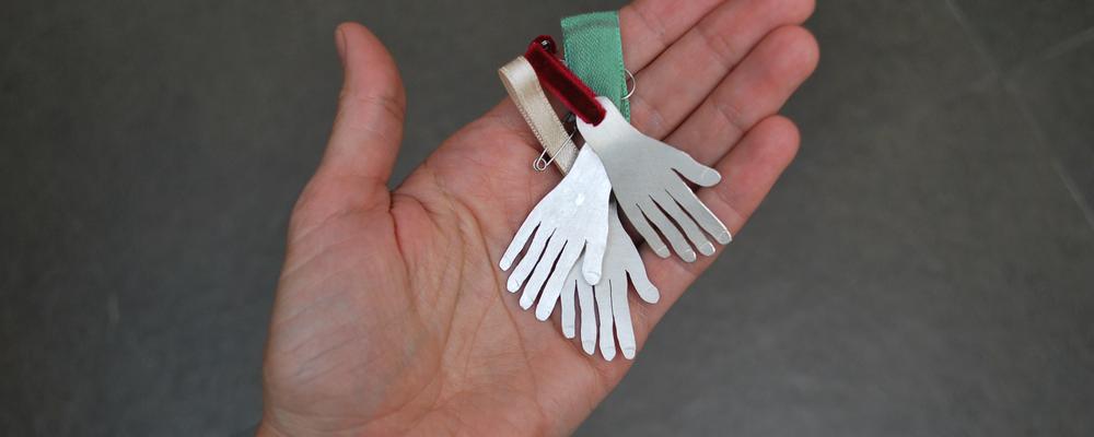 Picture of a hand holding hand shaped medals