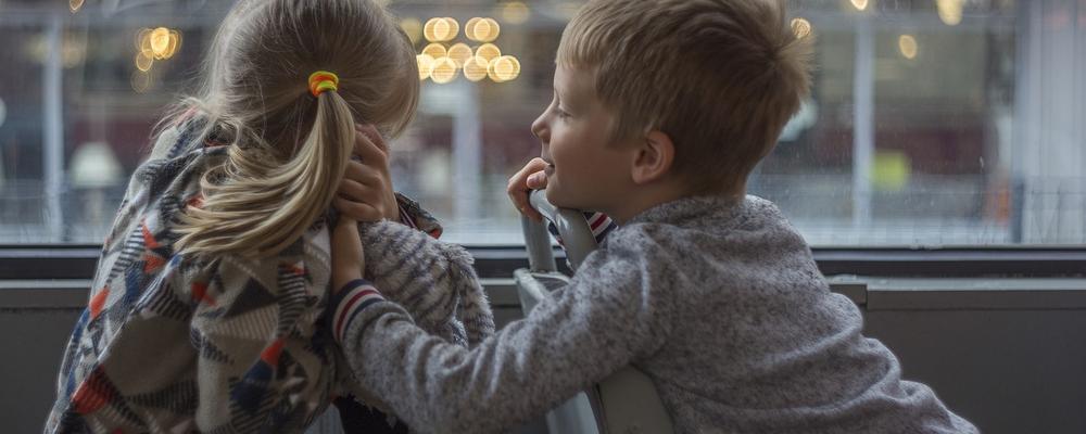 Young boy and girl talking on public transport