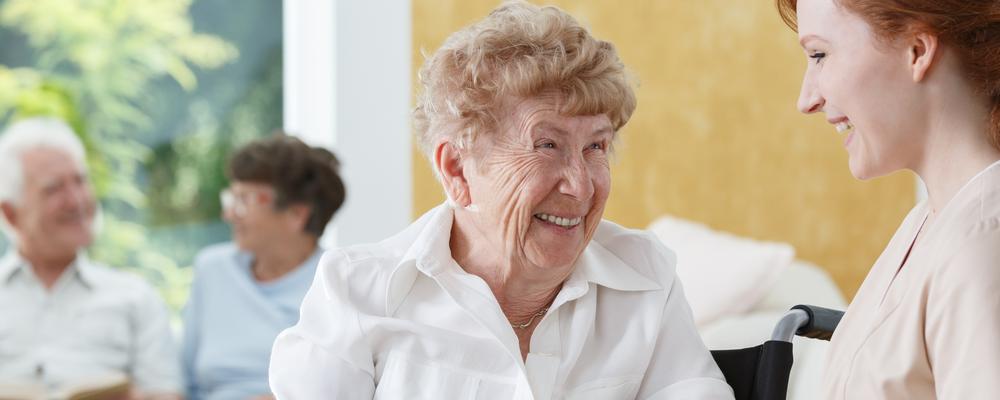 Glad äldre kvinna samtalar med yngre kvinna