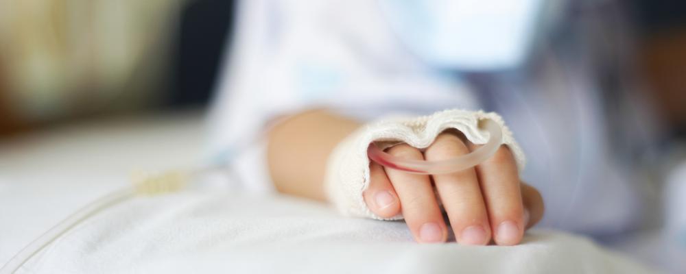 Foto på en barnhand med dropp