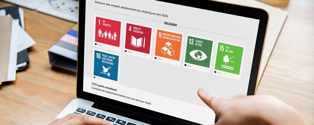 SDG Impact Assessment Tool on a laptop screen.